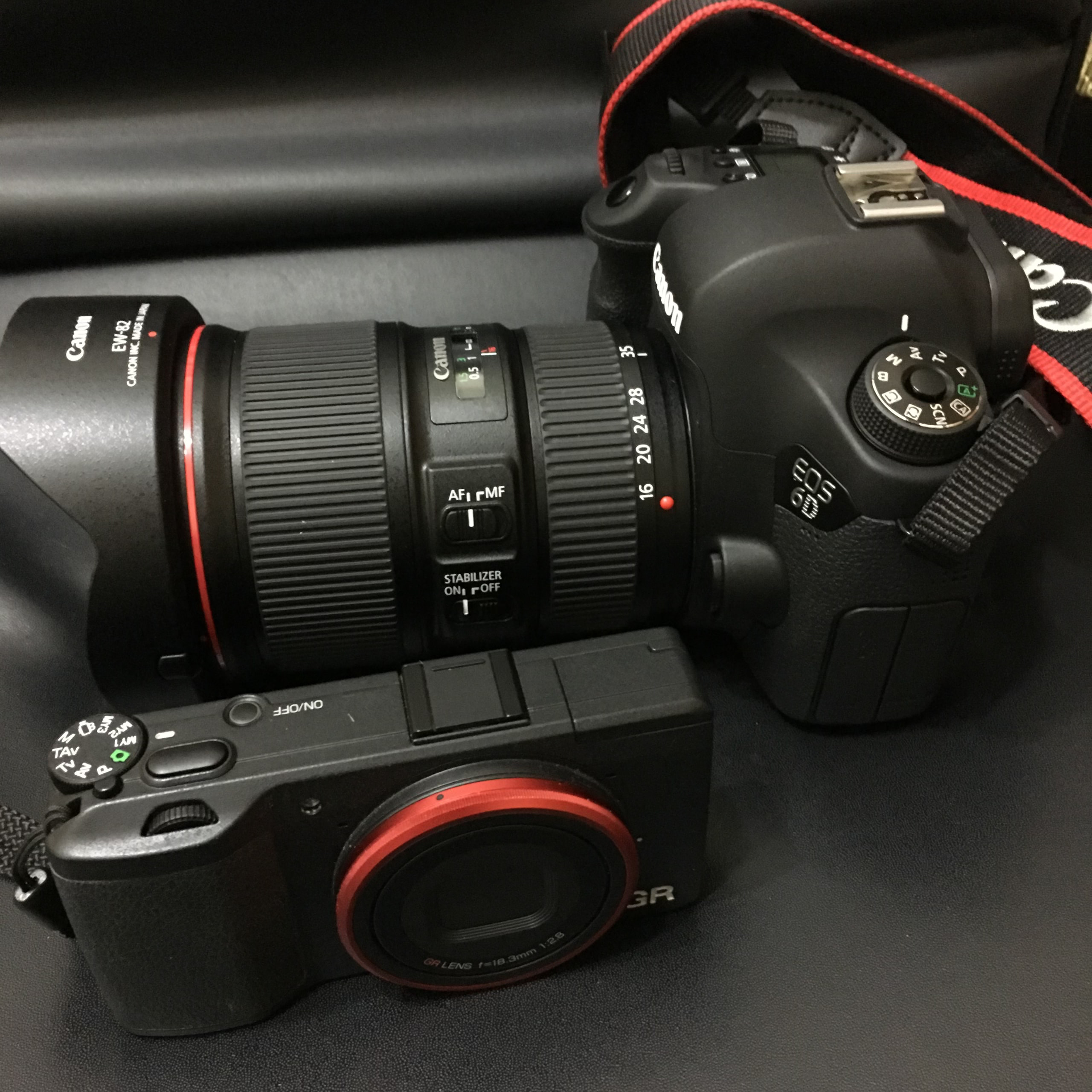 Canon 6D 與 Ricoh GR 並排放在椅面上